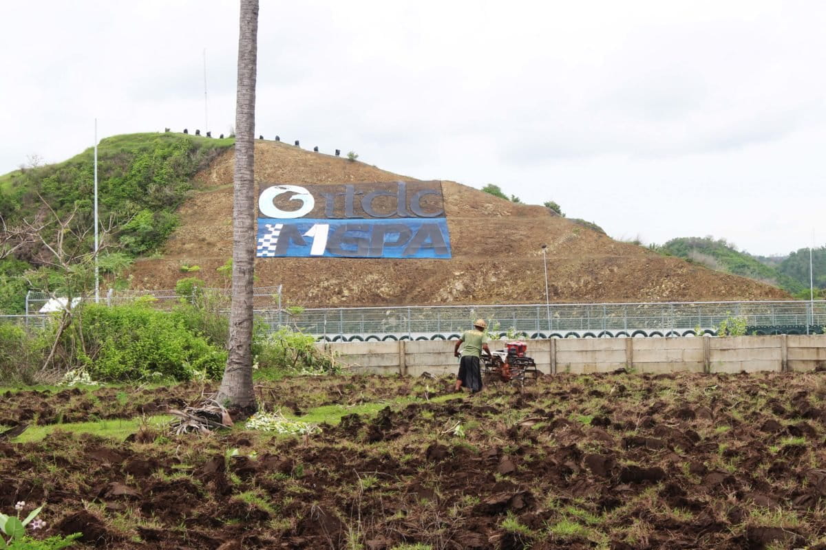 Buruh tani membajak lahan persis di samping Sirkuit Mandalika. Terlihat satu orang naik ke pohon untuk menonton perlombaan. Foto: Fathul Rakhman/Mongabay Indonesia