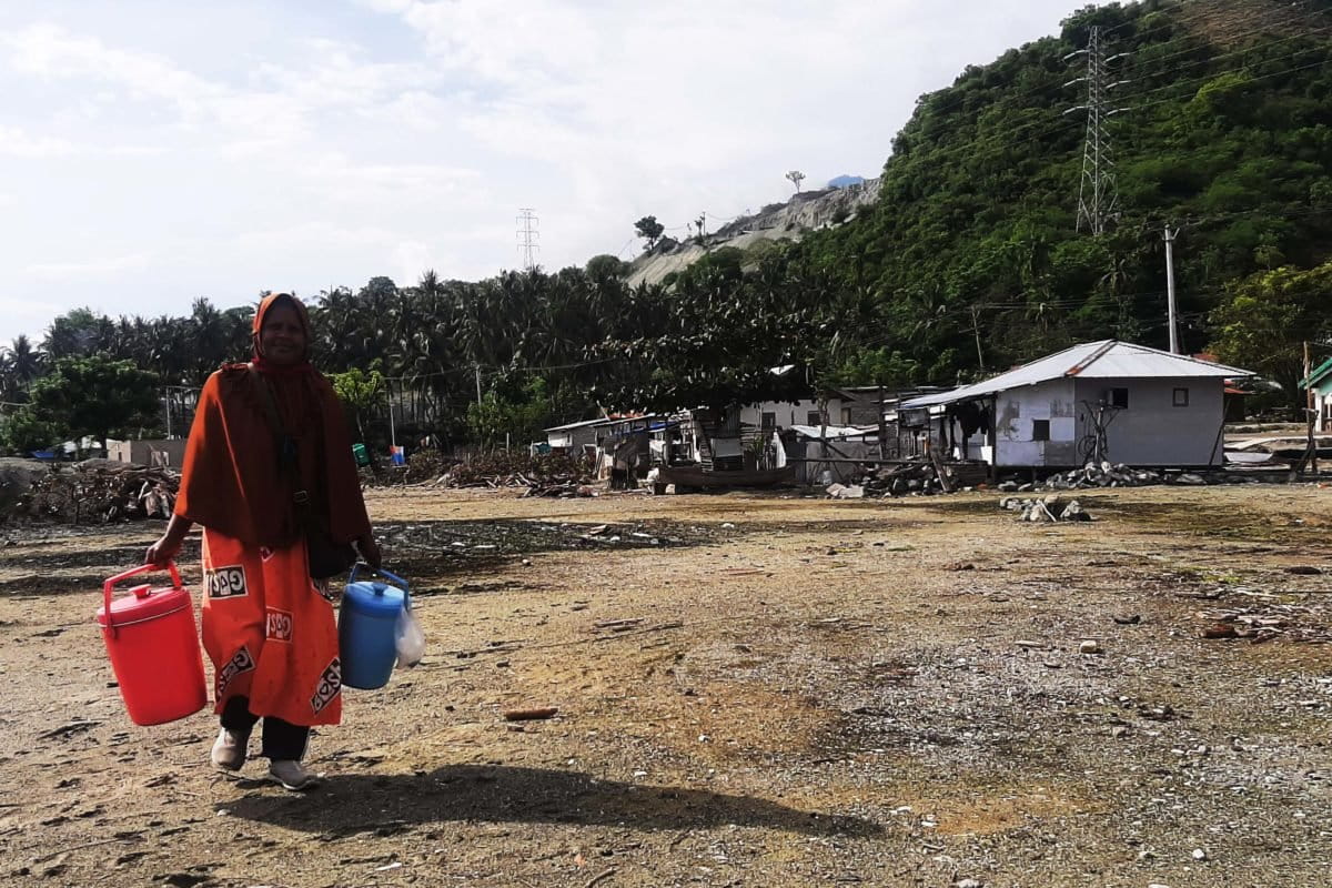 Nana dan termos biru – pinknya. Ikan tak lagi di dapatnya di laut tetapi di pasar. Foto: Rosmini 29/12/21)