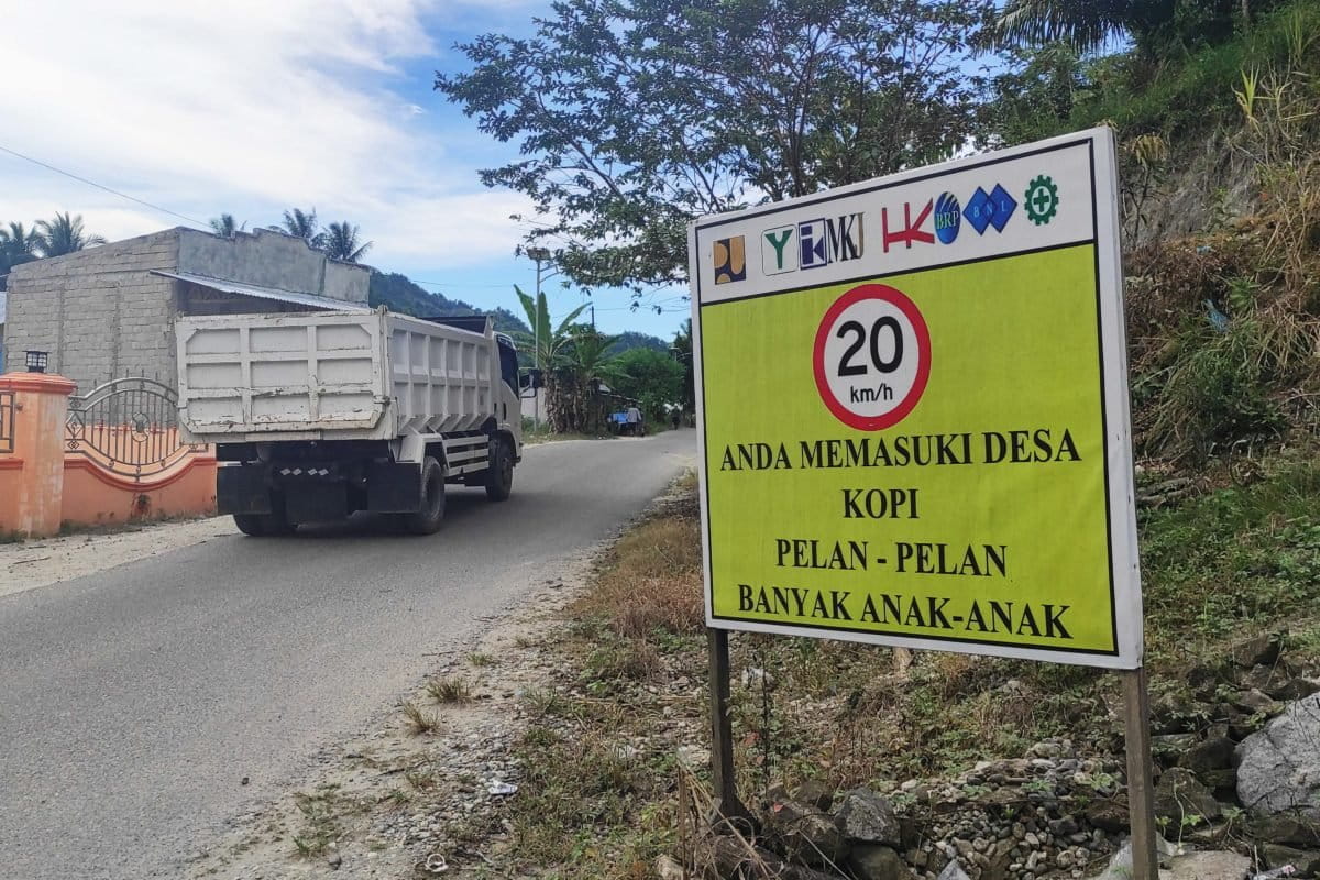 Peringatan bagi kendaraan proyek bendungan yang melewati Desa Kopi, harus pelan-pelan karena banyak anak-anak. Tak jarang pengemudi kendaraan melaju cepat, beberapa kecelakaan sudah terjadi, warga pun resah. Foto: Sarjan lahay/ Mongabay Indonesia