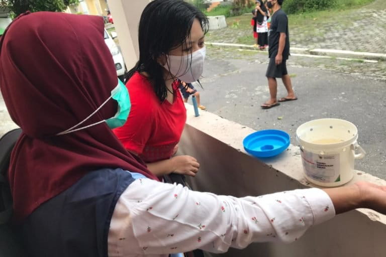 Kader Kesehatan menunjukkan ember berisi telur nyamuk ber-Wolbachia yang akan dititipkan di rumah warga. Foto: Dokumen WMP