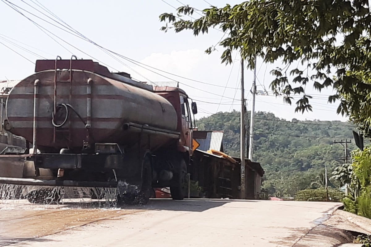 Jalan raya di Desa Sijantang, hampir setiap jam disiram oleh mobil tangkai. Penyiraman ini untuk mengurnagi debu batubara ke lingkungan dan masyarakt sekitar. Foto: Jaka HB? Mongabay Indonesia