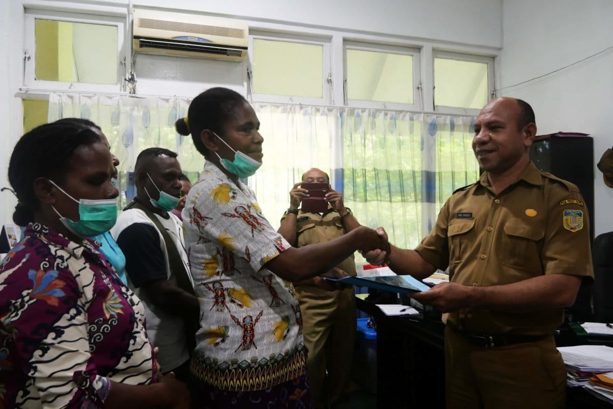 Rosita Tecuari saat menyerahkan pernyataan soal _Selamatkan Lembah Grime Nawa_ kepada Kepala Bidang Perkebunan Dinas Pertanian dań Tanaman Pangan Papua. Foto: Asrida Elisabeth/ Mongabay Indonesia