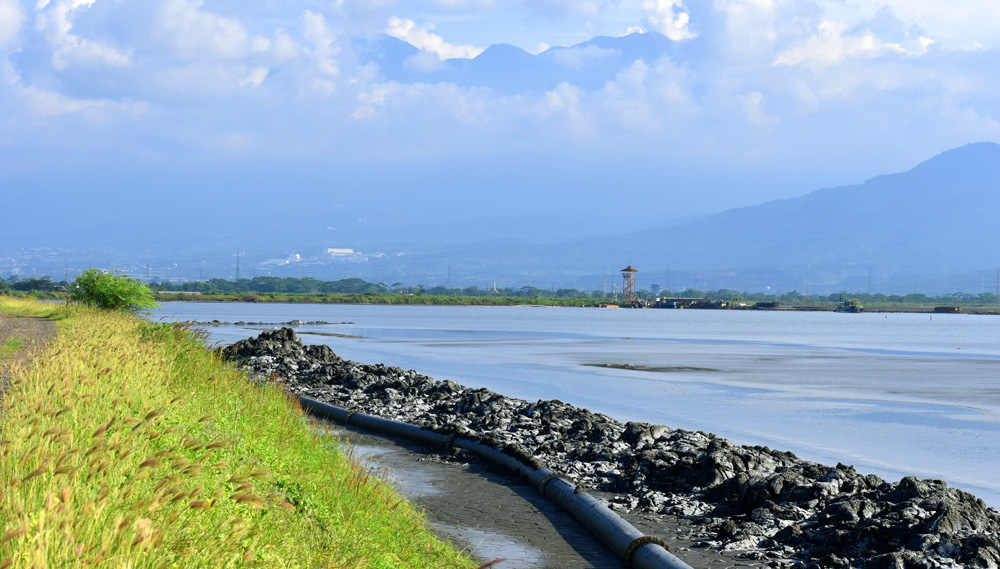 Danau lumpur Lapindo di Kabupaten Sidoarjo dengan latar belakang Gunung Penanggungan. Hingga kini lumpur terus menyembur tanpa diketahui kapan akan berhenti.