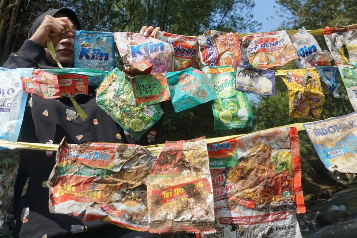 Para pemuda dan mahasiswa dari berbagai komunitas lingkungan membersihkan sampah plastik dan melakukan audit merek di Kali Metro, Merjosari, Kota Malang. (Foto: Komunitas Envigreen Society).