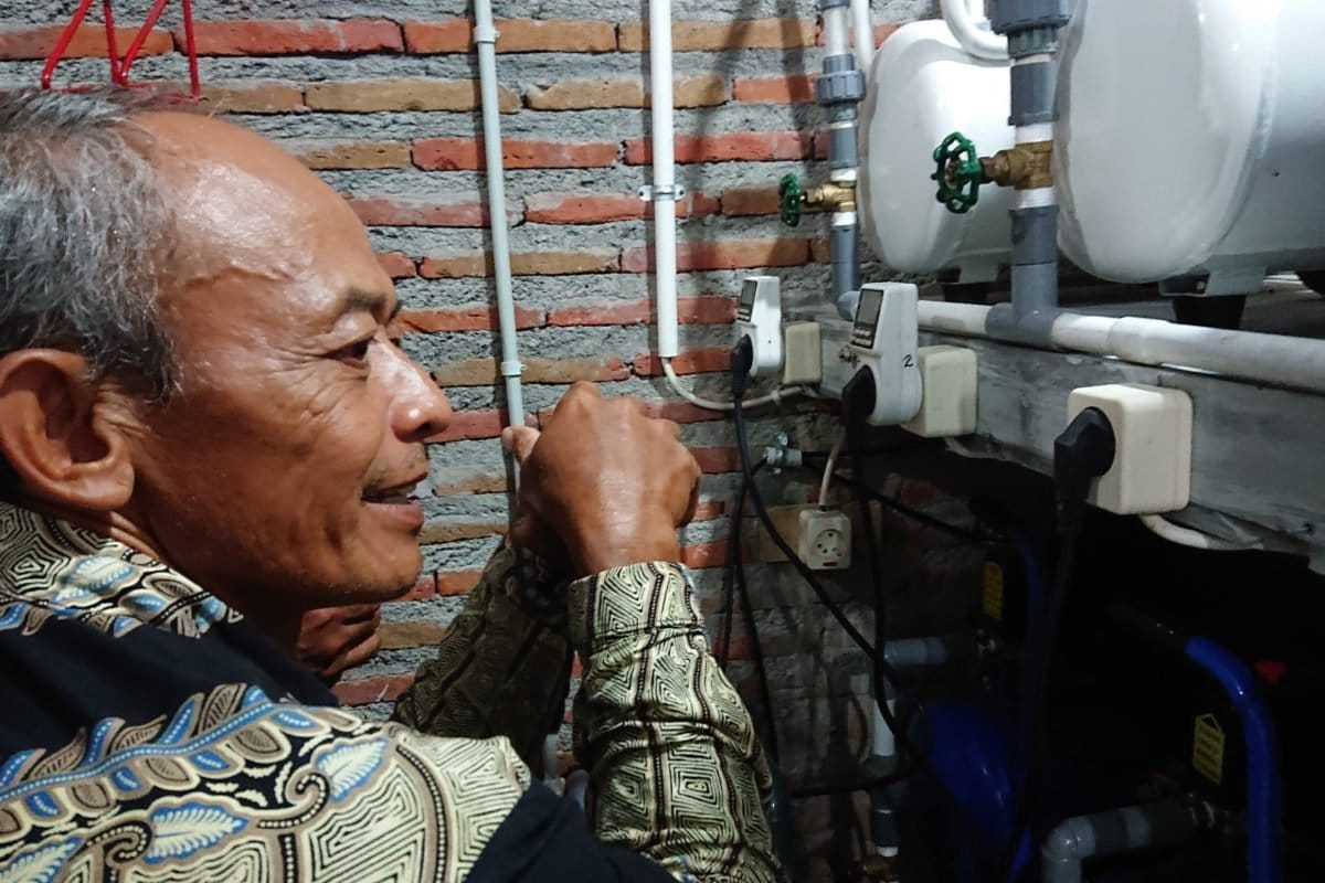 Sholikin warga desa Krendowahono dan peralatan kompresor untuk memampatkan gas rawa.
