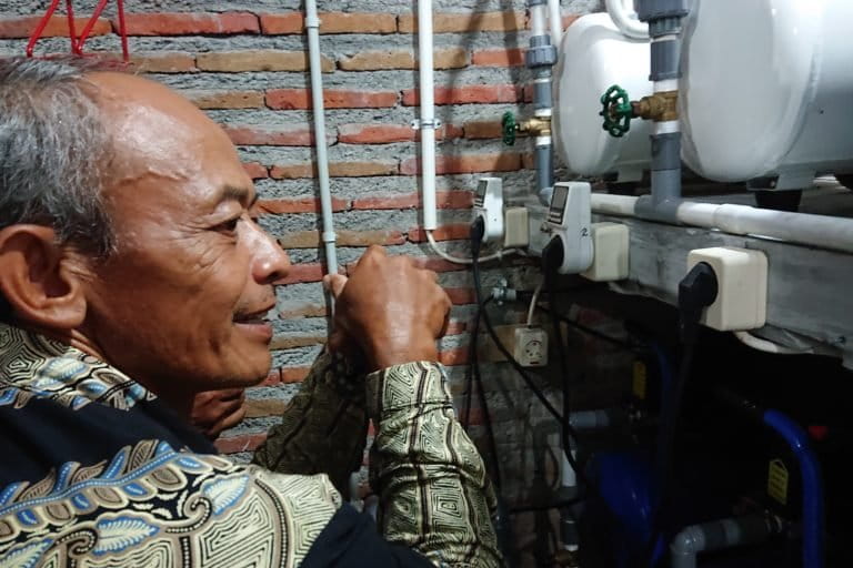 Sholikin warga desa Krendowahono dan peralatan kompresor untuk memampatkan gas rawa.