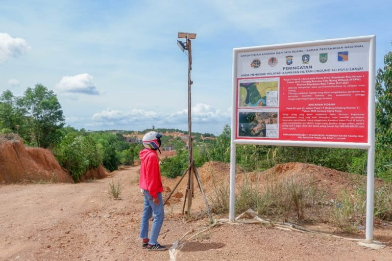 Seorang warga melihat plang peringatan larangan melakukan aktivitas di hutan lindung di Kawasan Sambau Nongsa Batam. Foto Yogi Eka Sahputra.JPG
