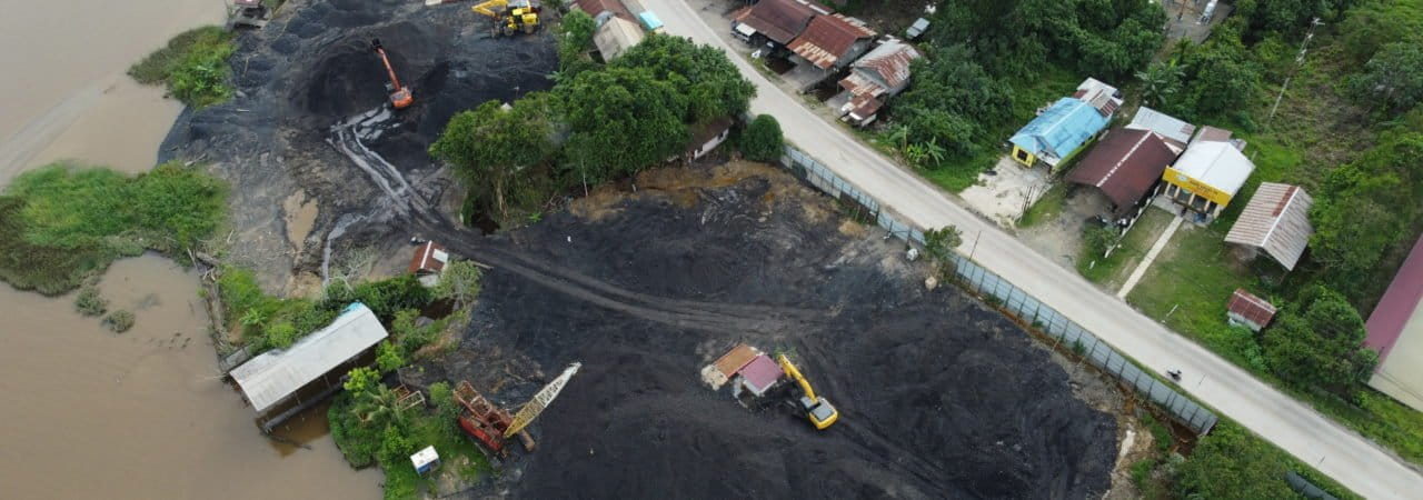 Tumpukan batubara ilegal berada di tepian sungai, yang berisiko mencemari perairan. Foto: Abdallah Naem/ Mongabay Indonesia