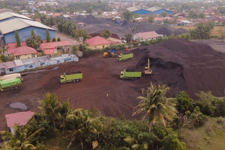 Stockpile PT EMI (bawah) di sebelah rumah warga dan membuat warga resah dua bulan belakangan. Foto: Jaka HB/ Mongabay Indonesia
