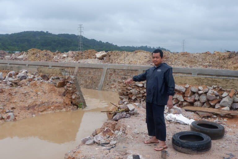 Warga menunjukan parit buatan perusahaan yang terlalu tinggi dari perumahan warga, sehingga air masuk ke kampung Tembesi Tower Sungai Beduk, Batam. Foto Yogi Eka Sahputra/Mongabay Indonesia