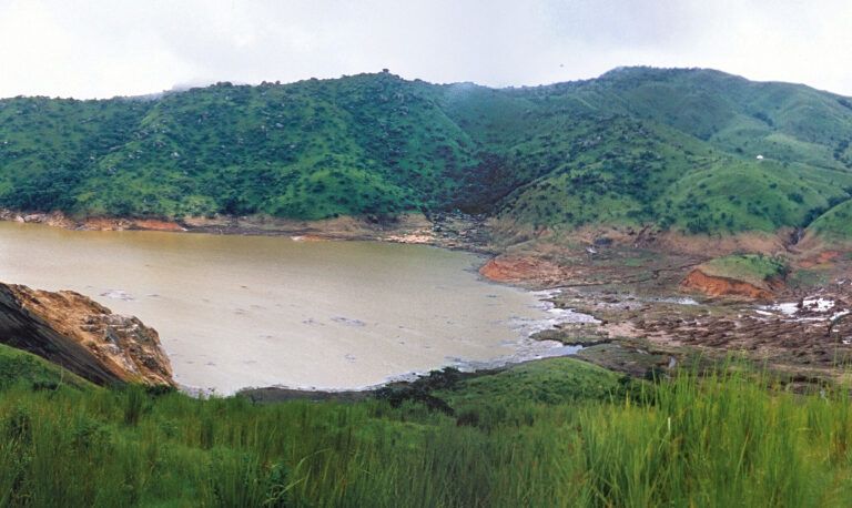 Dua foto yang digabungkan ini membentuk pemandangan semi-panoramik Danau Nyos, diambil pada 29 Agustus 1986, kurang dari sebulan setelah letusan limnik yang mematikan. Gambar ini menjadi saksi visual awal kondisi danau pasca-tragedi yang menewaskan lebih dari 1.700 orang dalam sekejap | Foto United States Geological Survey - United States Geological Survey
