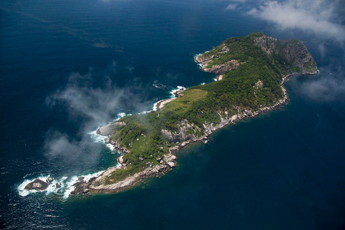 Ilha da Queimada Grande terlihat dari udara—pulau terpencil di lepas pantai Brasil yang dikenal sebagai Snake Island, rumah bagi ribuan ular berbisa Bothrops insularis. Pulau ini diklaim memiliki konsentrasi ular berbisa tertinggi di dunia. Foto: João Marcos Rosa / https://www.gov.br/