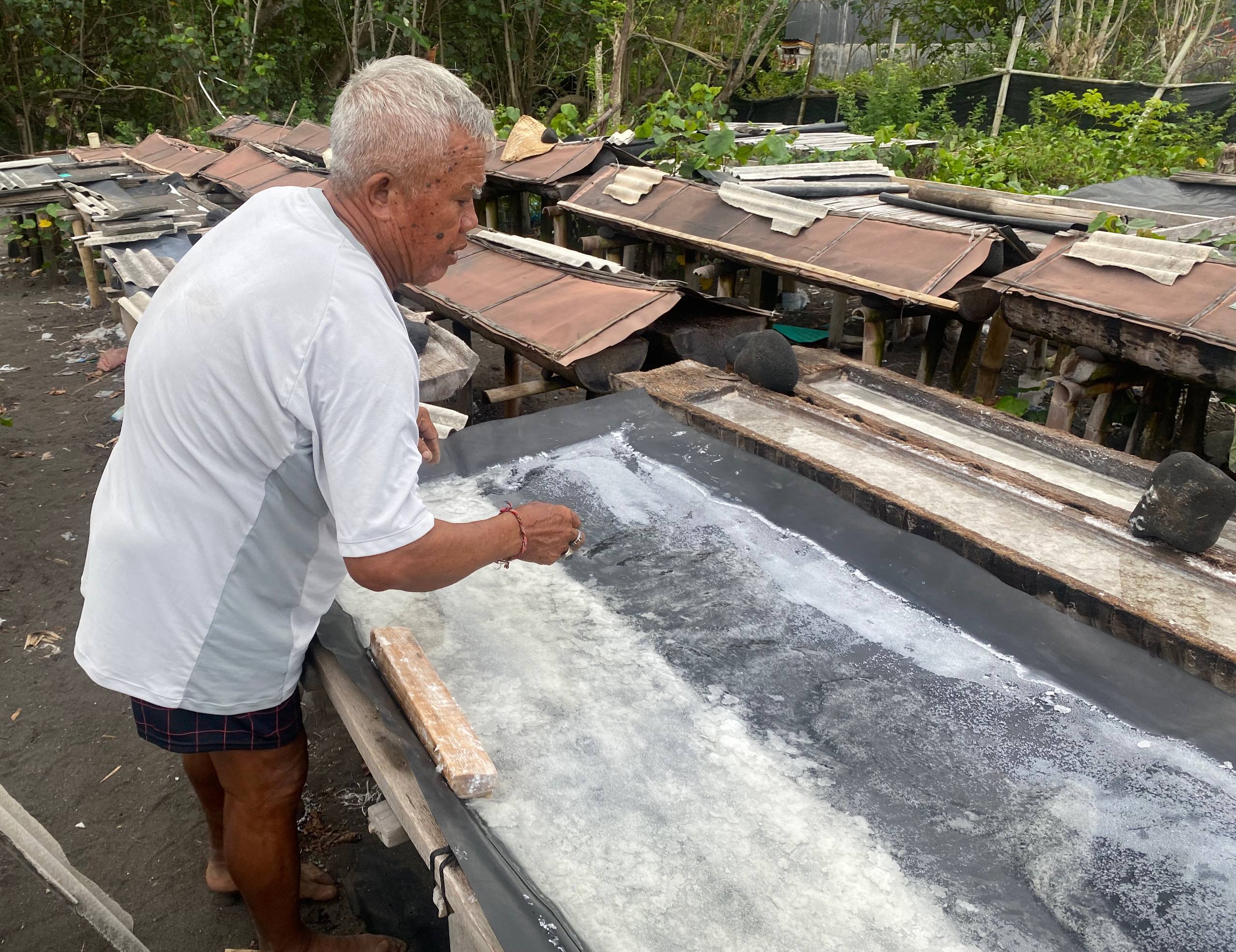 Nengah Bantat menunjukkan garam metode geomembran yang hampir siap panen. Foto: I Gusti Ayu Septiari/ Mongabay Indonesia