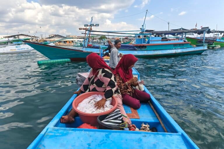 Novry bersama istri dan tetangganya menggunakan perahu menuju Pulau Kera, usai menjual hasil tangkapan, membeli air bersih, dan belanja kebutuhan rumah tangga di Pasar Oeba. Mobilitas laut seperti ini menjadi rutinitas mereka sehari-hari. Foto: Mario Sara/Mongabay Indonesia
