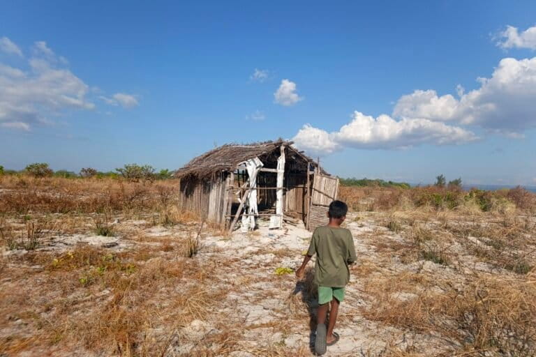Seorang remaja sedang melintas di depan pondok penampungan hasil panen, seusai membantu ibunya mengumpulkan rumput laut di perairan Pulau Kera. Foto: Mario Sara/Mongabay Indonesia