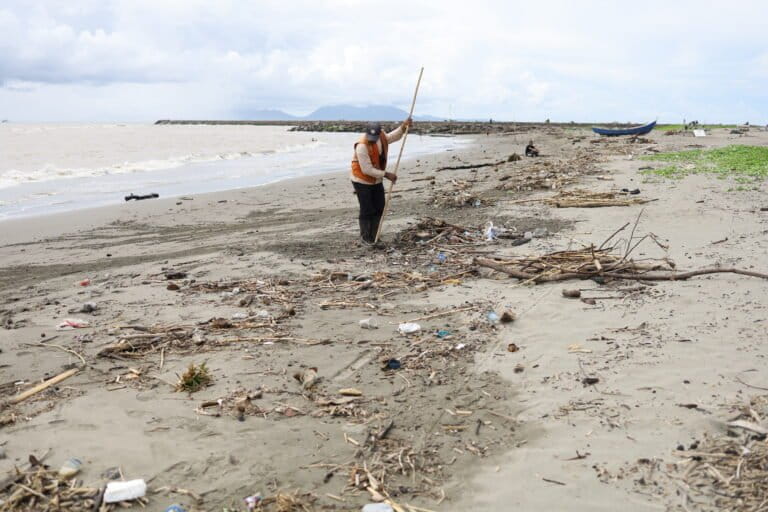 Petugas kebersihan mengumpulkan timbulan sampah berupa kayu, ranting pohon, dan plastik yang terbawa arus musim barat hingga sampai ke pesisir Pantai Gampong Jawa. Foto: Nurul Hasanah/Mongabay Indonesia